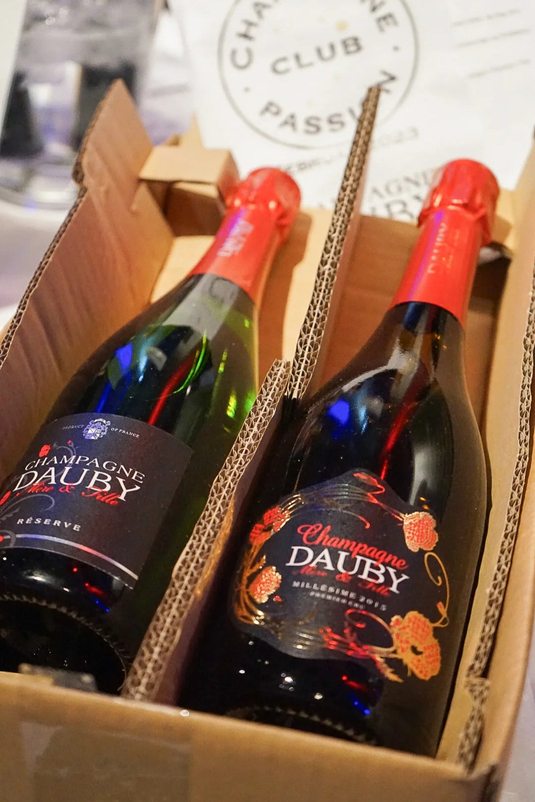 To flaske Champagne Dauby i en abonnementskasse