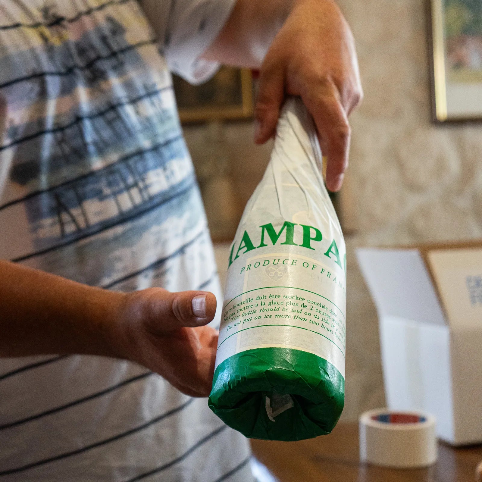 Adam Revolte champagne pakket ind i hvidt og grønt papir